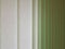 Fabric blinds in the form of green vertical stripes.