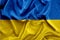 Fabric curved flag of Ukraine. Blue and yellow colors. UA flag background