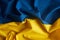 Fabric curved flag of Ukraine. Blue and yellow colors. UA flag background