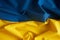 Fabric curved flag of Ukraine. Blue and yellow colors. UA flag background