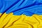 Fabric curved flag of Ukraine, UA. Blue and yellow colors. Close up shot, background