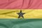 Fabric flag of Ghana. Crease of Ghanaian flag background.