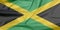 Fabric flag of Jamaica. Crease of Jamaican flag background.