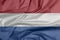 Fabric flag of Netherlands. Crease of Holland flag background.