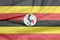 Fabric flag of Uganda. Crease of Ugandan flag background.