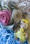 Fabric flowers surround mini teddy bear with yellow dress and jewel.