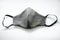 fabric grey mask with black elastic bands on a white background. top view