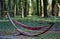 Fabric hammock net in designer hanging shape half moon crescent in park at sunrise springtime green leaves forest and red seduces