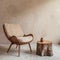 Fabric lounge chair and wood stump side table against beige stucco wall with copy space. Rustic minimalist home interior design of