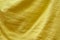 Fabric of mustard color with smooth wavy folds