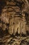 Fabulous abstract background of stalactites, stalagmites and stalagnates in a cave underground, vertical