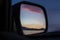 A fabulous beautiful pink sunset reflected in the mirror of a distant view of the car on Lake Baikal in winter.