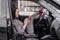 fabulous Female wearing checkered dress in an automobile with legs in red high-heeled shoes sticking out car window