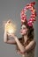 A fabulous girl with floral horns and fantastic make-up holds a glowing ball.