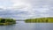 A fabulous landscape of a Finnish lake in the midst of a dense Scandinavian green forest. The concept of calm and quiet rest in