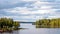 A fabulous landscape of a Finnish lake in the midst of a dense Scandinavian green forest. The concept of calm and quiet rest in