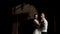 Fabulous wedding couple standing against black wall with the shadow from the metal gate. Action. Portrait of young bride