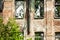 Facade abandoned brick building overgrown with grass and trees