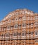 Facade of the ancient Palace of Winds with lots of windows and turrets on a sky background, Jaipur, India