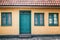 Facade of a beige building with a green door, background and tex