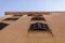 Facade of beige Mediterranean Spanish houses against a clear blue sky