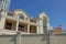 Facade of a brown private house with windows behind the fence against the sky