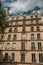 Facade of building with balcony and leafy tree in Paris