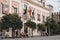 Facade of Casa de la Provincia on Plaza del Triunfo, Seville, Spain, people sitting on benches outside