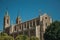 Facade of Cathedral in Gothic style among leafy trees in Madrid