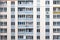 Facade of condominium. Multi-storey residential building. Abstract texture. Wall with windows and balconies of Russian and Ukraini