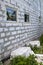 facade of cottage under construction with new inserted windows. Blocks of foam concrete blocks sawn from walls under size of