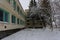 The facade of the destroyed and abandoned bakery building against the background of winter trees. The structure of the times of t