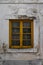 Facade detail of old traditional house with yellow wooden window frame