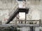 Facade, entrance and staircase of an abandoned and ruined  two story house.