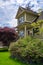 Facade of family house with stairwell to main entrance and green lawn in front