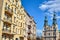 Facade of a historic tenement house and belfries of the baroque church