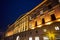 The facade of a historic tenement house in the neoclassical style at night