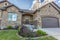 Facade of home with lush yard in front of stone wall and gable roofs