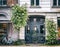 Facade of a house in the historic quarter of Copenhagen, a door, a bicycle, rose bushes, an image with retro toning