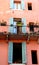 Facade of a house, with two windows and a glass door to Verona