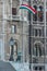 Facade of the Hungarian Parliament Building with the statue of a guarding lion and a flag