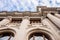 Facade of large institutional building with large columns and windows, background sky, low angle shot, in Valencia