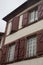 Facade of medieval building. Exterior of ancient house with wooden window shutters. Vintage architecture. Village of middle age.