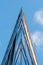 Facade of modern office building with glass and steel under blue sky, reflections and selective focus.