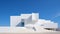 The facade of a modern white building stands against a backdrop of clear blue sky