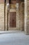 Facade of old abandoned stone bricks wall with grunge weathered wooden door, Cairo, Egypt