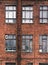 Facade of an old brick building in loft style. High Windows and textural materials
