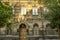 Facade of old building of multicolored tufa stone with carved arches