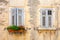 Facade of an old dirty house with blue shutters