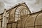 Facade of an old glass arch building against a cloudy sky in sepia